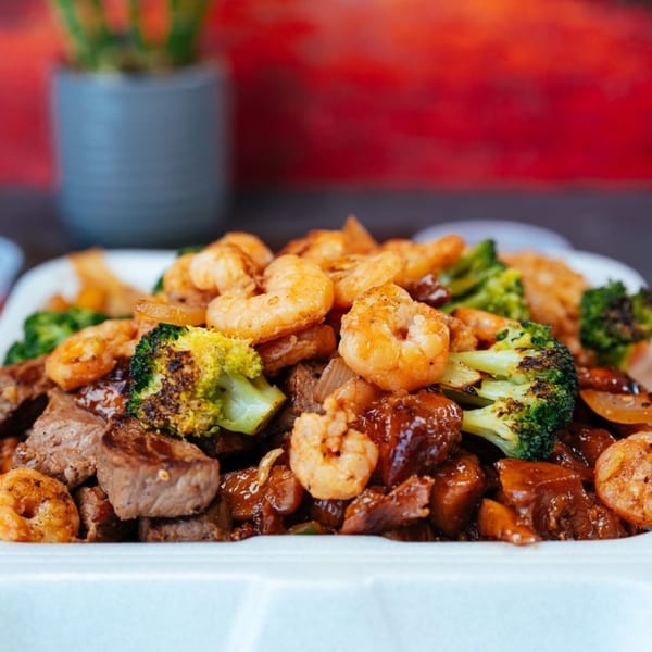 Tokyo Express Grill's hibachi steak and shrimp with broccoli in a white takeout container.