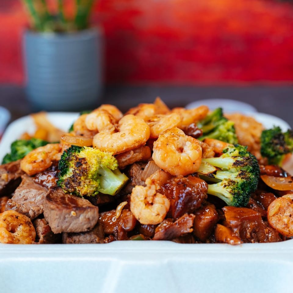 Tokyo Express Grill's hibachi steak and shrimp with broccoli in a white takeout container.