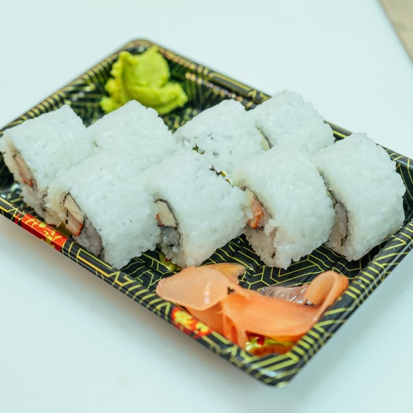 Eight pieces of Tokyo Express Grill sushi rolls with wasabi and ginger in a takeout container.